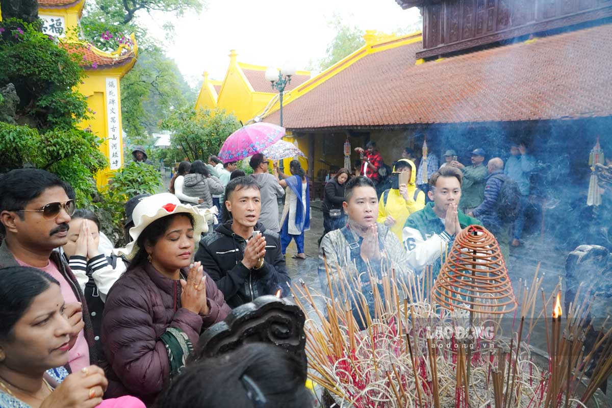 Mặc dù trời mưa, nhưng du khách khi đến chùa Trấn Quốc vẫn rất thích thú với kiến trúc cổ kính của ngôi chùa cũng như phong tục lễ bái của người dân Việt Nam. Ảnh: Hồng Diệp - Hiệp Phạm