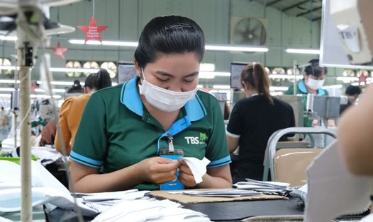 Chị Kim Thị Tha Huy (Tiểu Cần - Trà Vinh) bị khuyết tật ở chân được bố trí công việc dán keo giày phù hợp với thể trạng sức khỏe. Ảnh: Phương Anh