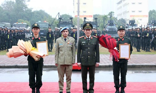 Thượng tướng Lương Tam Quang - Thứ trưởng Bộ Công an và Tư lệnh Cảnh sát Liên Hợp Quốc Faisal Shahkar trao quyết định thành lập Đơn vị Cảnh sát Gìn giữ hoà bình số 1. Ảnh: TTXVN
