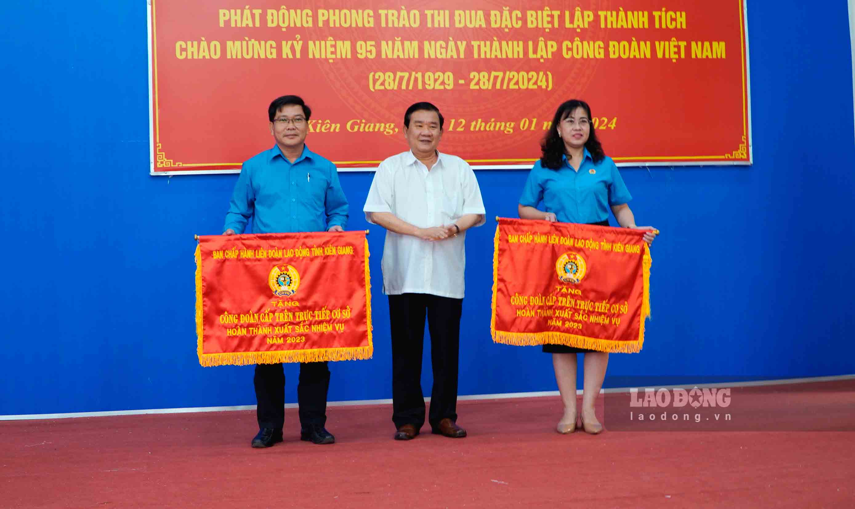 Ông Nguyễn Văn Phích - Trưởng Ban Dân vận Tỉnh ủy trao Cờ thi đua của LĐLĐ tỉnh cho 2 công đoàn cấp trên trực tiếp cơ sở dẫn đầu cụm thi đua. Ảnh: Nguyên Anh