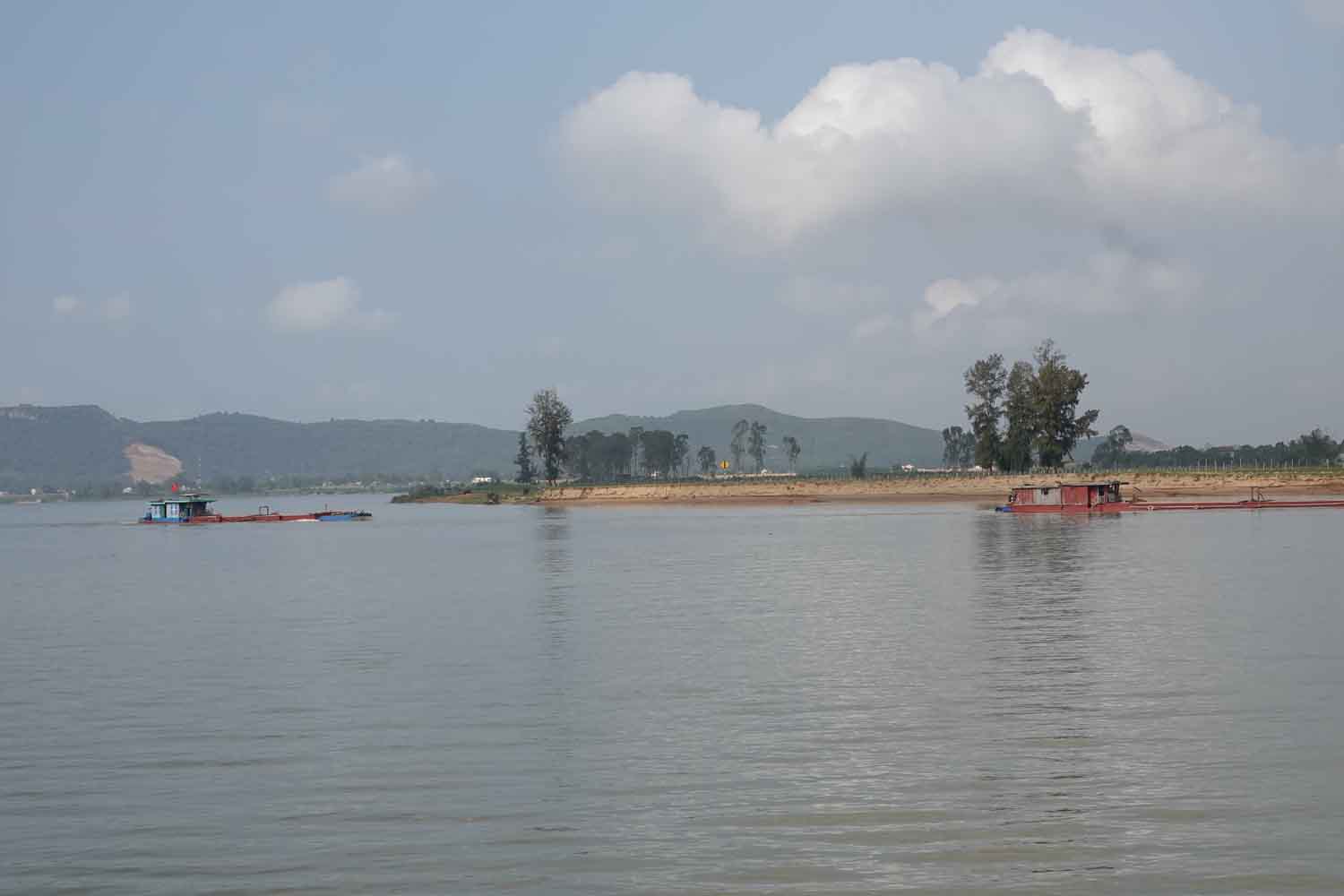 Tàu chở cát qua lại trên sông để đưa về bãi tập kết bên bờ sông Lam đoạn sạt lở nặng nề ở xã Xuân Lam. Ảnh: Trần Tuấn.