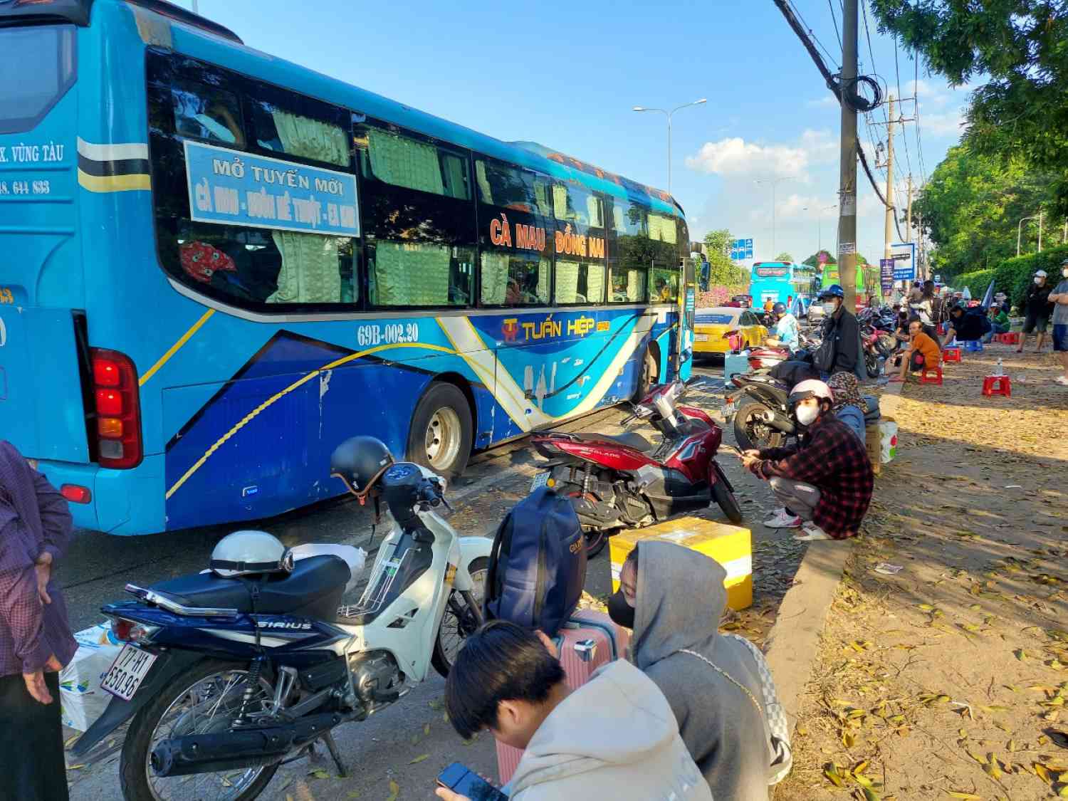 Người dân vạ vật đón xe dù trên Quốc lộ 1 đoạn qua TP Thủ Đức.  Ảnh: Minh Quân