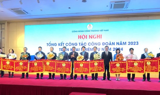 Phó Chủ tịch Tổng LĐLĐVN Huỳnh Thanh Xuân (thứ 4, từ trái sang) trao tặng Cờ Thi đua của Tổng LĐLĐVN cho 12 tập thể thuộc Công đoàn Công Thương Việt Nam. Ảnh: Hà Anh