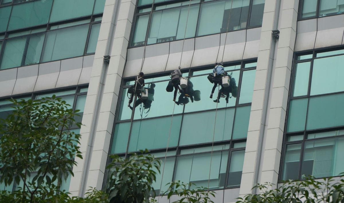 Những tòa cao ốc cũng đang được tổng vệ sinh. Hình ảnh công nhân thực hiện lau kính tại tòa nhà cao tầng trên đường Hàm Nghi.