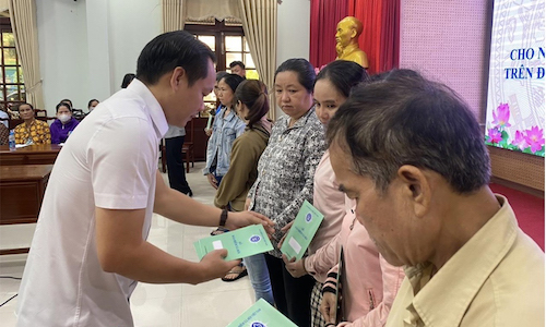 Đại diện BHXH Việt Nam tặng sổ BHXH cho người dân tỉnh Bình Dương. Ảnh: BHXHVN