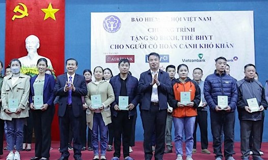 Tổng Giám đốc BHXH Việt Nam Nguyễn Thế Mạnh (thứ 4 từ phải sang) trao tặng sổ BHXH, thẻ BHYT cho người có hoàn cảnh khó khăn tại tỉnh Hoà Bình. Ảnh: BHXHVN