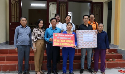 Các thành viên trong gia đình bà Bùi Thị Nhị quây quần nhận kinh phí hỗ trợ xây nhà mái ấm. Ảnh: Bá Mạnh