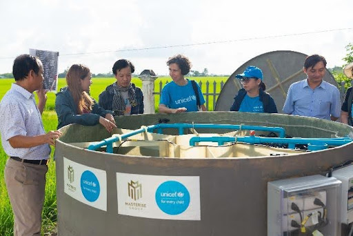 Cán bộ UNICEF và đại diện địa phương lắp đặt thiết bị của nhà vệ sinh không phát thải (trái). Ảnh: Thủy Phạm