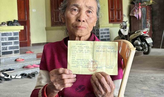 Bà Hồ Thị Tần, 75 tuổi, xã Mỹ Thành với cuốn sổ tiết kiệm do tiệm vàng Tám Nhâm phát hành với số nợ 70 triệu từ năm 2016 ghi tên người chồng đã mất. Ảnh: Quang Đại