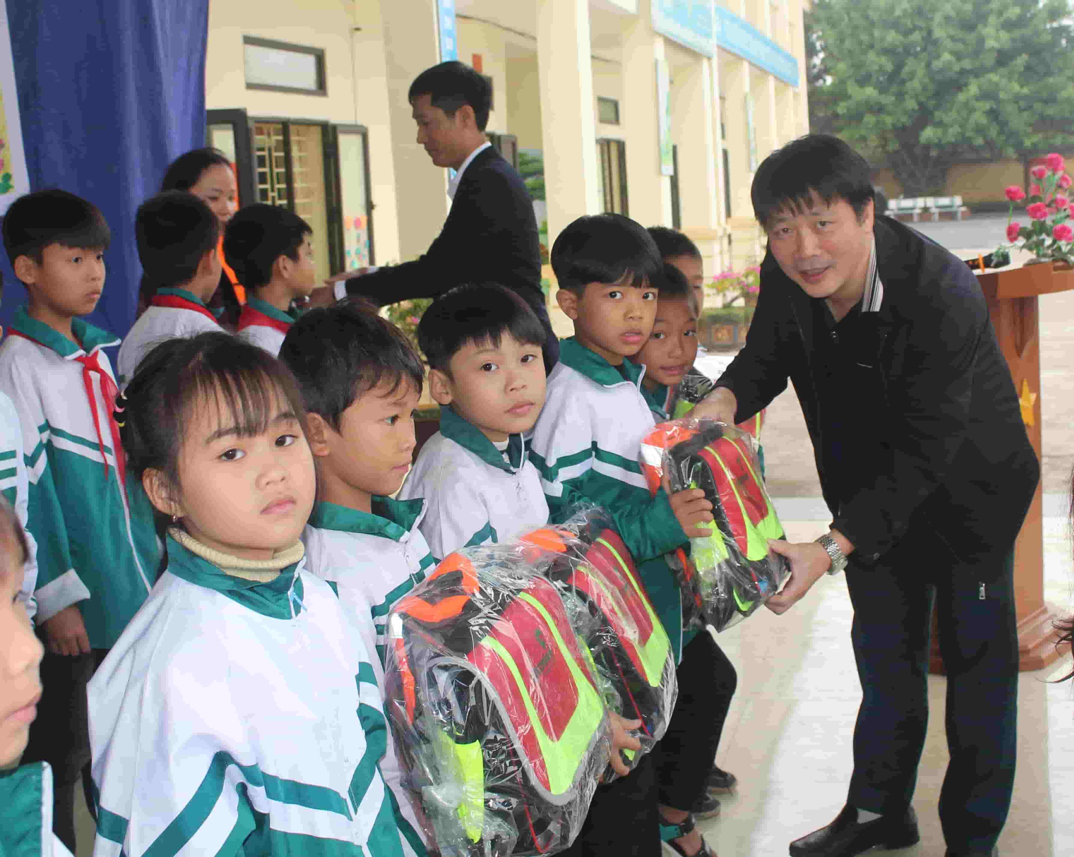 Ông Nguyễn Xuân Hùng - đại diện Quỹ Xã hội từ thiện Tấm lòng Vàng trao cặp cho các em học sinh trên địa bàn huyện Kim Sơn. Ảnh: Nguyễn Trường