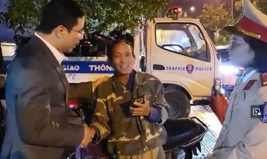 Đại tá Nguyễn Hồng Phong - Giám đốc Công an tỉnh Hà Tĩnh (bên trái) dặn dò người thợ xây lần sau uống rượu không được điều khiển phương tiện tham gia giao thông sẽ nguy hiểm. Ảnh cắt từ clip.