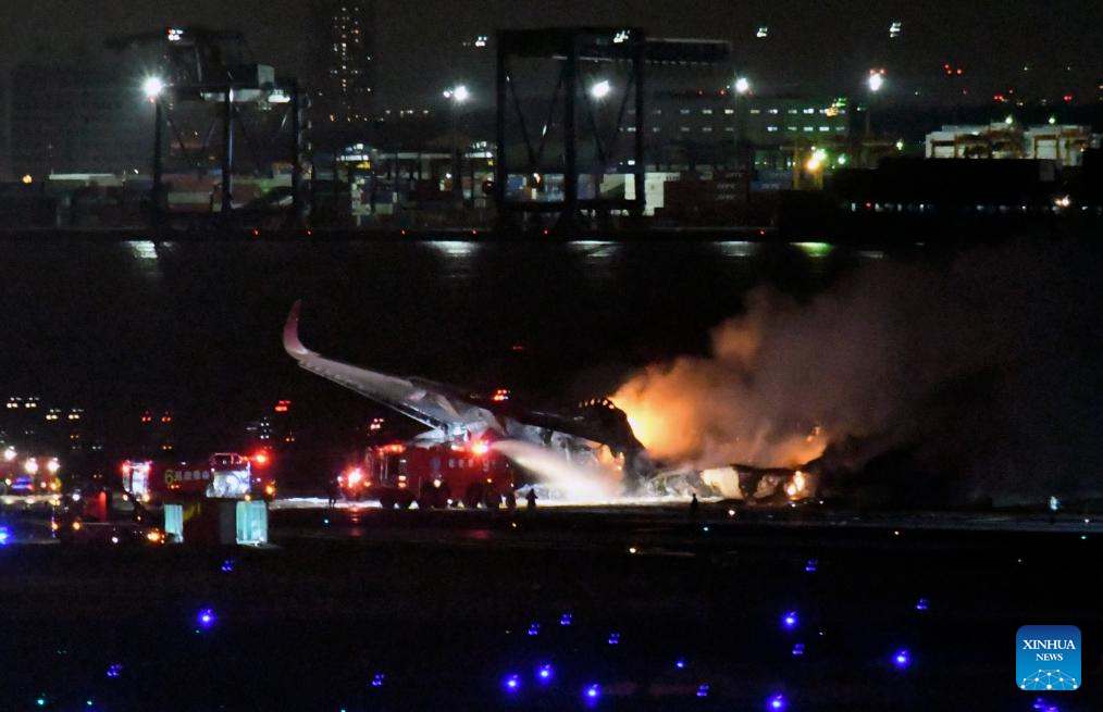 Máy bay của Japan Airlines chìm trong biển lửa. Ảnh: Xinhua