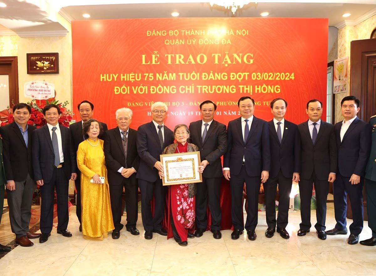 Bí thư Thành ủy Đinh Tiến Dũng và các đại biểu dự buổi lễ trao Huy hiệu 75 năm tuổi Đảng tặng bà Trương Thị Hồng. Ảnh: Viết Thành