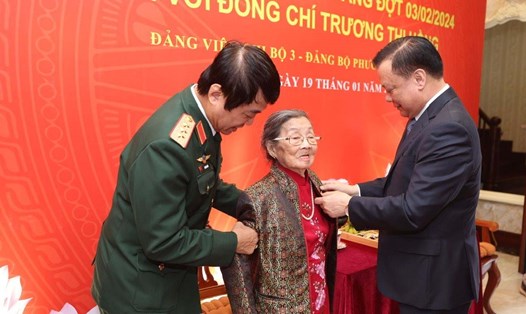 Bí thư Thành ủy Hà Nội Đinh Tiến Dũng gắn Huy hiệu 75 năm tuổi Đảng tặng bà Trương Thị Hồng. Ảnh: Viết Thành