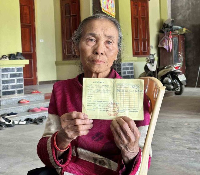 Bà Hồ Thị Tần, 75 tuổi, xã Mỹ Thành với cuốn sổ tiết kiệm do tiệm vàng Tám Nhâm phát hành với số nợ 70 triệu từ năm 2016 ghi tên người chồng đã mất. Ảnh: Quang Đại