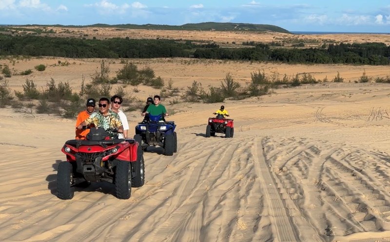 Du khách Hàn Quốc trải nghiệm xe địa hình trên đồi cát Bàu Trắng, Bình Thuận. Ảnh: Duy Tuấn