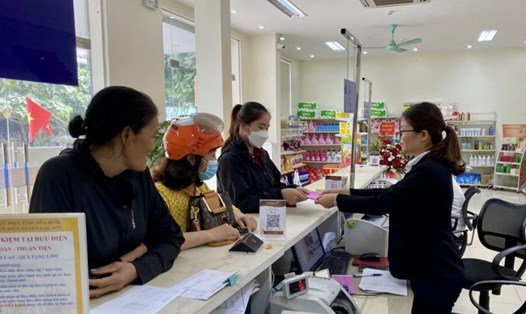 Bưu điện huyện Lạc Sơn chi trả chính sách an sinh xã hội cho đối tượng hưởng trợ cấp xã hội trên địa bàn thị trấn Vụ Bản. Ảnh: Bùi Minh