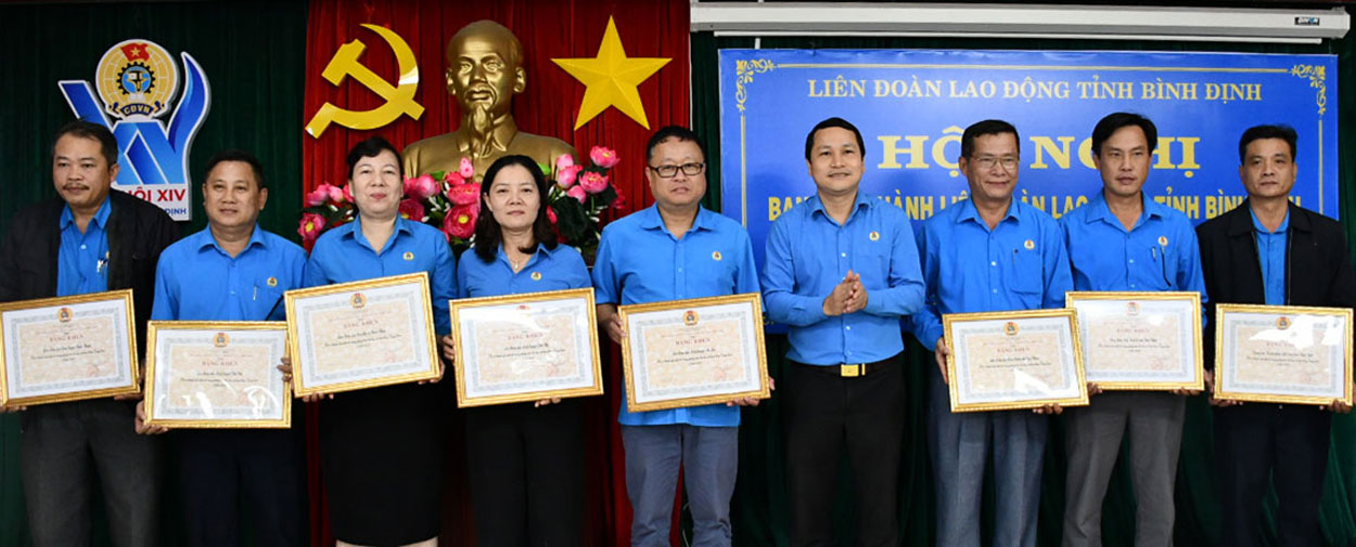 Chủ tịch LĐLĐ tỉnh Bình Định Hà Duy Trung tặng bằng khen cho 8 tập thể xuất sắc. Ảnh: Xuân Nhàn.