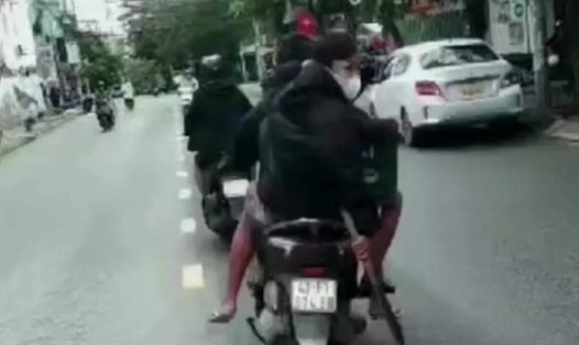 3 thanh thiếu niên tham gia giao thông không đội mũ bảo hiểm, mang theo mã tấu di chuyển trên đường phố. Ảnh: Cắt từ video