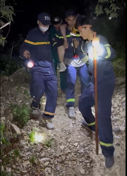 Các cán bộ chiến sĩ Phòng Cảnh sát phòng cháy chữa cháy và cứu nạn, cứu hộ Công an tỉnh Khánh Hòa cõng một trong 2 du khách kiệt sức vì mắc kẹt ở núi Cô Tiên trong đêm. Ảnh: Hoàng Anh
