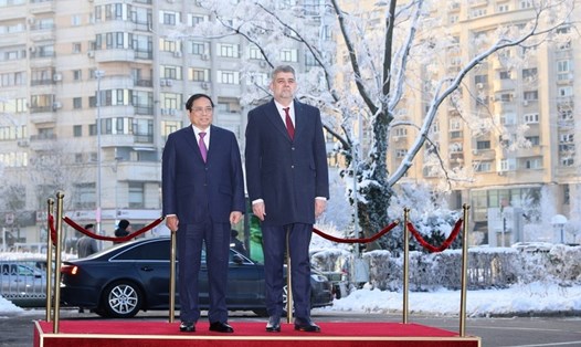 Thủ tướng Chính phủ Phạm Minh Chính và Thủ tướng Romania Ion-Marcel Ciolacu nghe quân nhạc cử quốc thiều hai nước. Ảnh: TTXVN