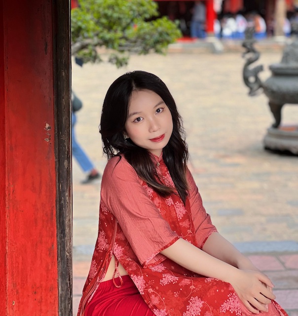 Chị Đỗ Kiều Anh lựa chọn bộ áo dài đỏ chụp ảnh trước cổng Đại Thành khu di tích Văn Miếu. Ảnh: Ngọc Minh. 