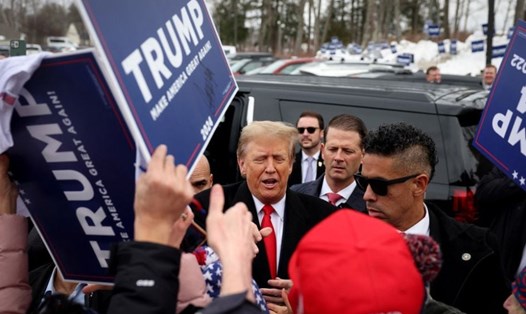 Ông Donald Trump (giữa) đến điểm bỏ phiếu ở Londonderry, New Hampshire, Mỹ, ngày 23.1.2024. Ảnh: Reuters