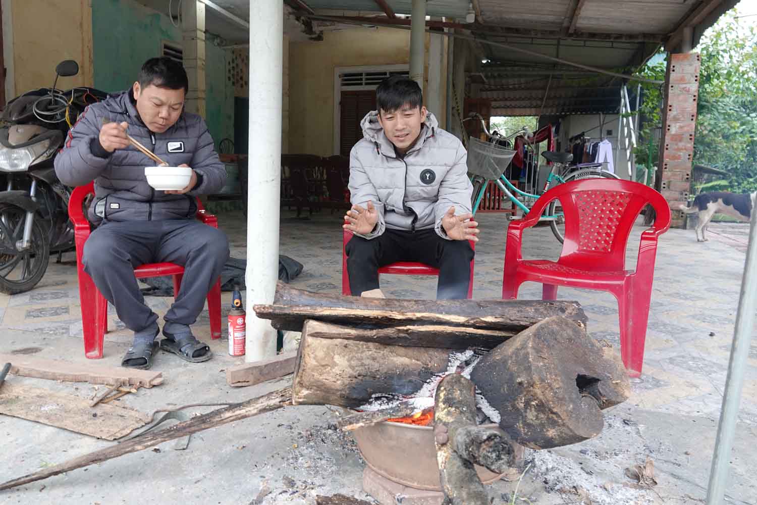 Không những người già mà nhiều thanh niên cũng không muốn rời khỏi bếp lửa vì trời quá rét. Trong ảnh là anh Phạm Văn Linh (36 tuổi, trú thôn Tân Lộc, xã Nam Điền) cùng bạn đang sưởi ấm. Ảnh: Trần Tuấn.