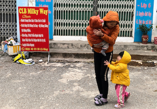 Chị Kiều Thị Hậu đi đón 2 con giữ trời giá rét. Ảnh: Bảo Hân 