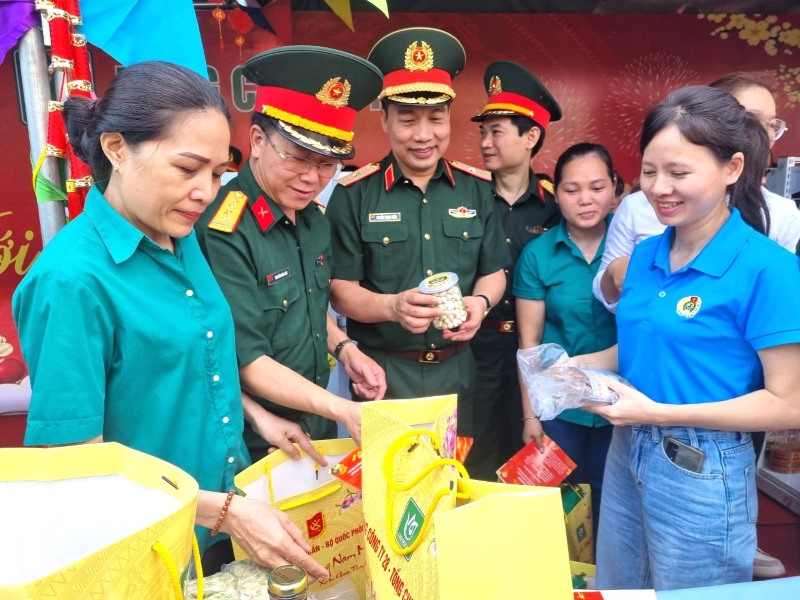 Đại tá Nguyễn Đình Đức và thiếu tướng Nguyễn Trọng Thiện (thứ hai, ba từ trái qua), chung vui với người lao động được tặng quà. Ảnh: Nam Dương
