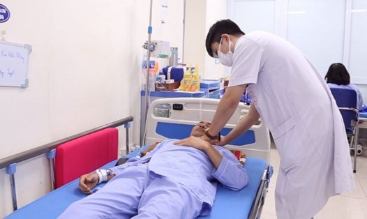 Bác sĩ tại khoa Bệnh Nhiệt đới và Can thiệp giảm hại, Bệnh viện Đại học Y Hà Nội thăm khám cho bệnh nhân. 
Ảnh: Bệnh viện cung cấp