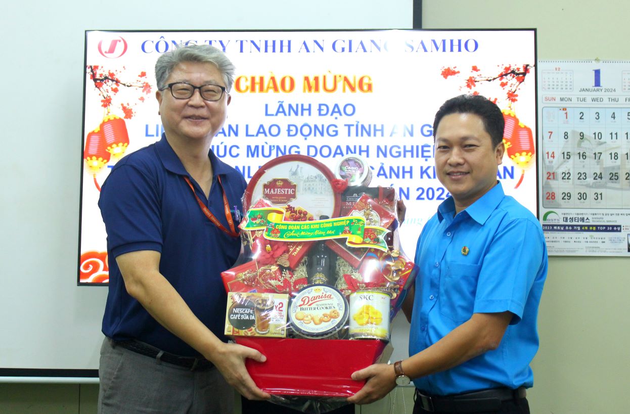 Chủ tịch LĐLĐ tỉnh An Giang Lâm Thành Sĩ tặng quà cho đại diện doanh nghiệp tại Khu Công nghiệp Bình Hòa. Ảnh: Lâm Điền