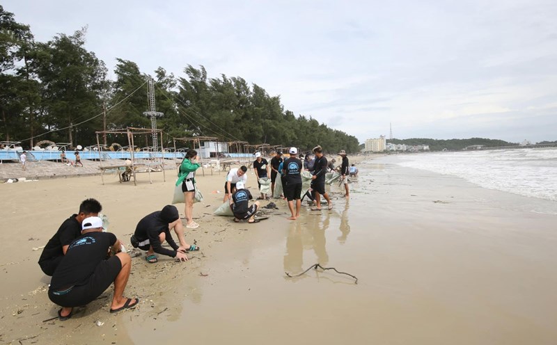 Khách du lịch tham gia nhặt rác, làm sạch biển Cô Tô. Ảnh: Đoàn Hưng