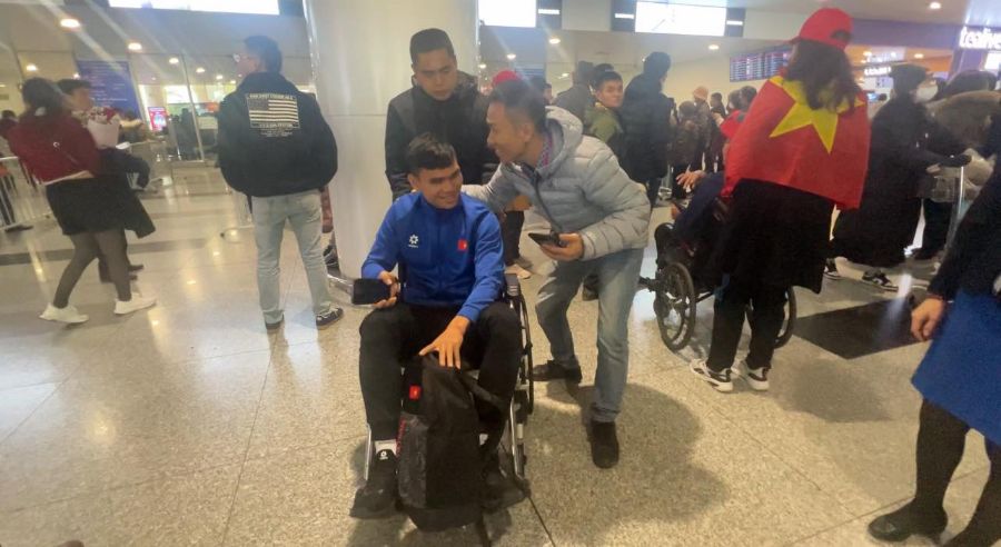 Hậu vệ Xuân Mạnh ngồi xe lăn khi về đến sân bay Nội Bài. Ảnh: Hoàng Công