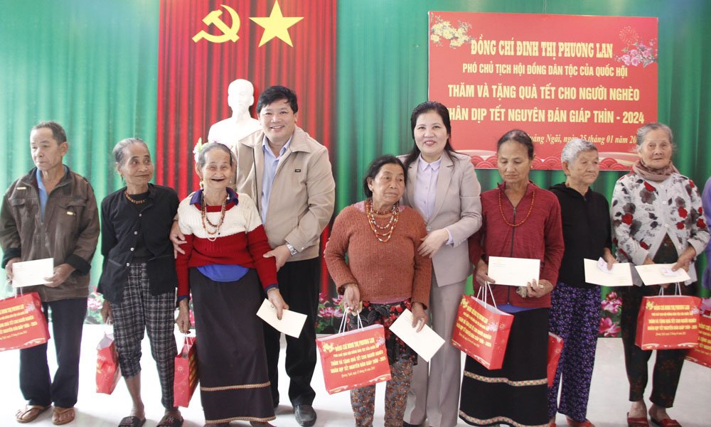 Phó Chủ tịch Hội đồng Dân tộc của Quốc hội Đinh Thị Phương Lan tặng quà cho người dân ở các huyện Minh Long, Sơn Tây. Ảnh: Ngọc Viên
