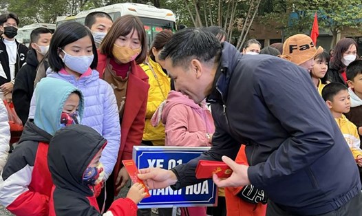 Cán bộ Công đoàn Hà Nội mừng tuổi con của công nhân tại lễ tiễn công nhân về quê đón Tết bằng xe miễn phí của Công đoàn. Ảnh: Kiều Vũ