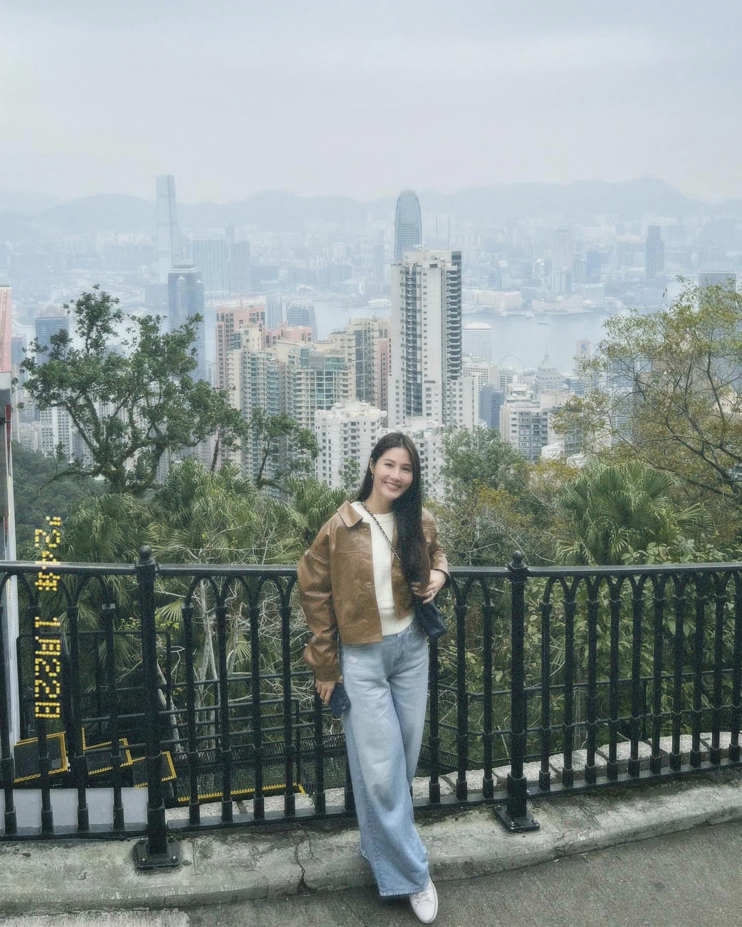 Đi bộ dọc đường lên đỉnh núi, cặp đôi dừng chân chụp ảnh, thu về khung cảnh Hong Kong (Trung Quốc) từ trên cao. Tuy nhiên, do điều kiện thời tiết mà khung cảnh phía sau có lớp sương mờ bao phủ.