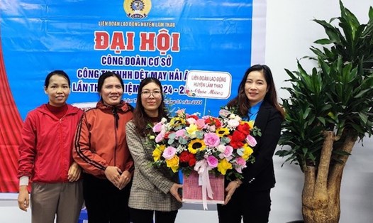 Lãnh đạo Liên đoàn Lao động huyện Lâm Thao tặng hoa chúc mừng Ban Chấp hành Công đoàn cơ sở Công ty TNHH Dệt may Hải Âu. Ảnh: Kim Tuyến 