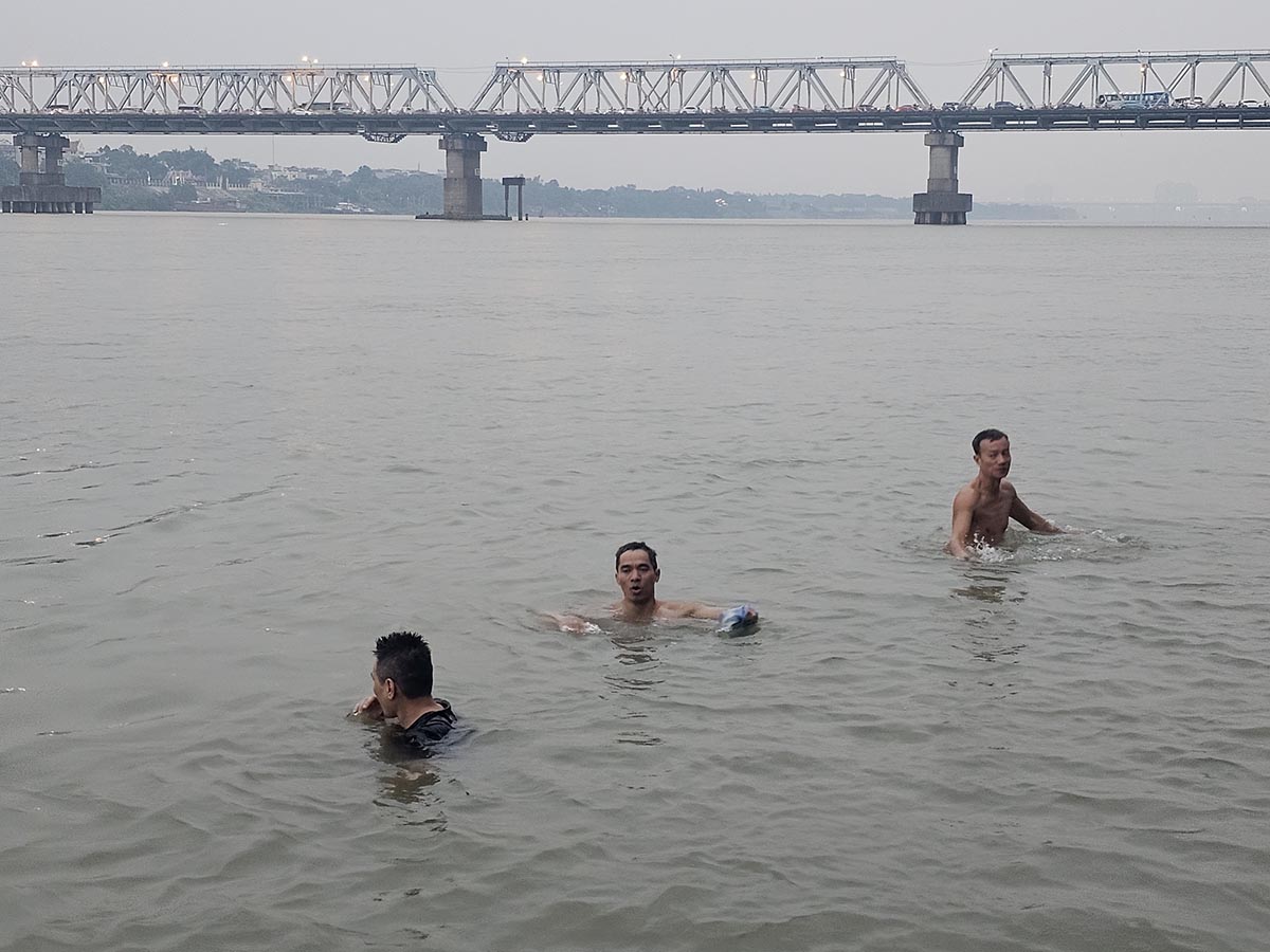 Dù nhiệt độ giảm sâu, nhiều người dân vẫn duy trì thói quen ra sông Hồng, đoạn chân cầu Long Biên (Hà Nội) để tắm.
