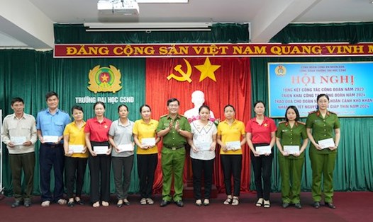 Thượng tá Phan Văn Đuộc - Chủ tịch Công đoàn trao quà Tết cho đoàn viên có hoàn cảnh khó khăn. Ảnh: Trường Đại học CSND.
