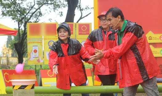 3 nghệ sĩ Trinh Trinh, Hòa Hiệp, Quyền Linh đội mưa thực hiện thử thách. Ảnh: Bee