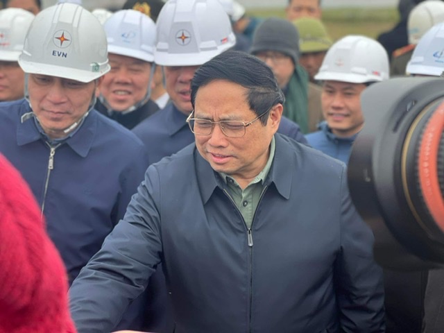 Thủ tướng Phạm Minh Chính và đoàn công tác nghe báo cáo tiến độ thi công dự án. Ảnh: Cường Ngô