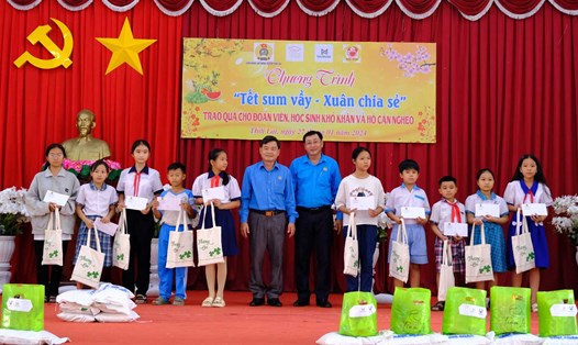 Phó Chủ tịch LĐLĐ TP Cần Thơ Đoàn Văn Dũng (trái) và Chủ tịch LĐLĐ huyện Thới Lai Phan Thanh Sang (phải) trao học bổng cho các em học sinh. Ảnh: Mỹ Ly