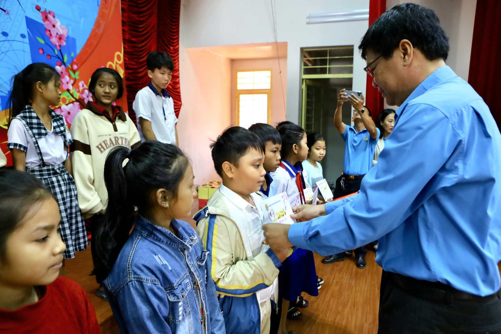 Ông Đỗ Hữu Quy - Chủ tịch LĐLĐ tỉnh Bình Thuận trao quà Tết cho các em nhỏ. Ảnh: Duy Tuấn 