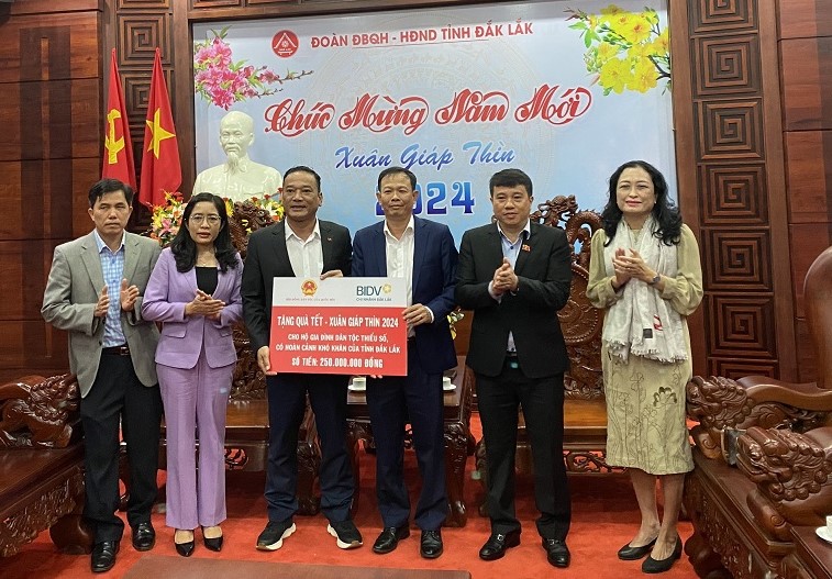 Ông Y Thanh Hà Niê Kđăm, Ủy viên Ban Chấp hành Trung ương Đảng, Chủ tịch Hội đồng Dân tộc của Quốc hội (thứ 2 từ phải sang) tặng quà Tết cho người dân ở Đắk Lắk. Ảnh: Bảo Trung