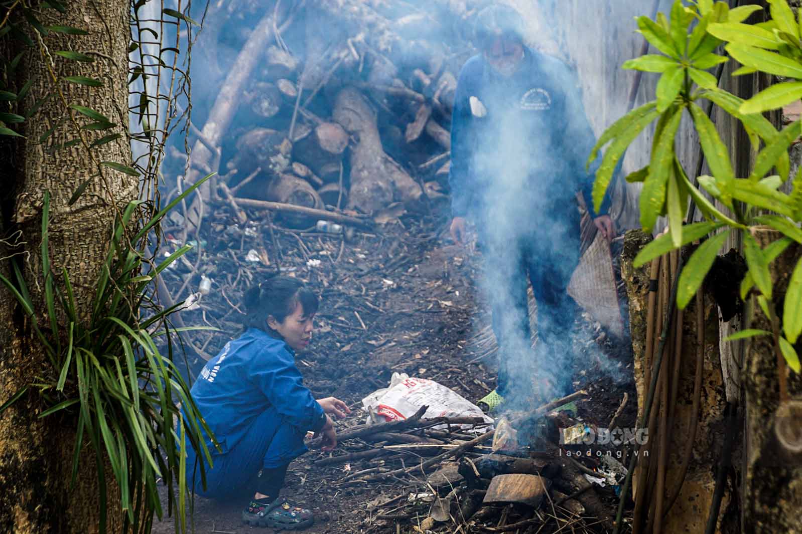 Công nhân đang mồi củi lửa giữ ấm cho động vật.
