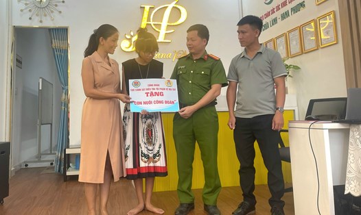 Thiếu tá Nguyễn Đăng Khoa - Chủ tịch Công đoàn Cục Cảnh sát điều tra tội phạm về ma túy - trao hỗ trợ cho cháu Tuyền. Ảnh: Hạnh An