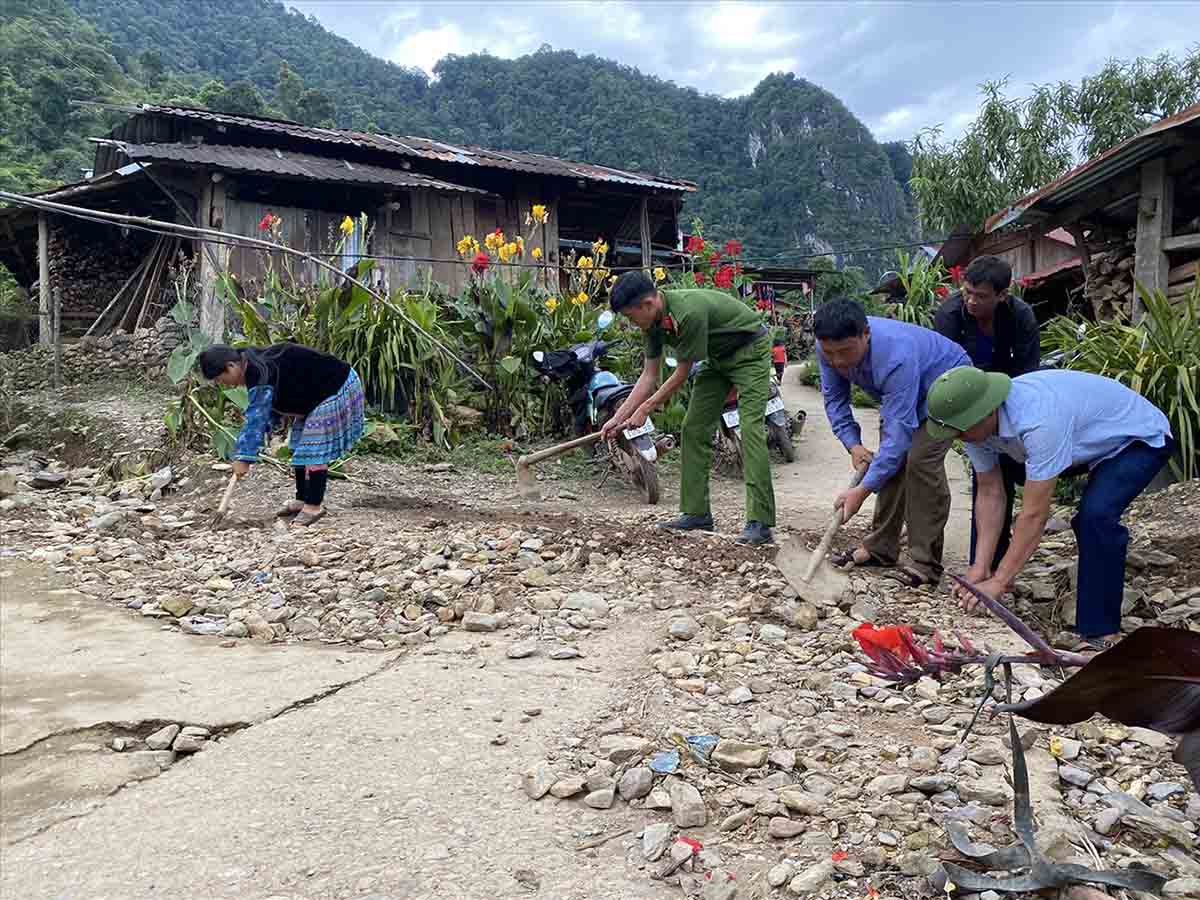 Lực lượng công an giúp dân dọn dẹp, sửa sang đường đi lại. Ảnh: Tào Đạt