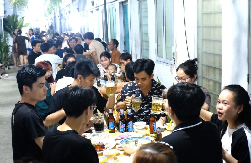 Người lao động ăn tiệc tất niên do gia đình ông Nguyễn Thành Tâm tổ chức. Ảnh: Đức Long