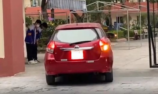 Học sinh cúi chào ôtô của các thầy cô ra, vào trường. Ảnh cắt từ clip. 